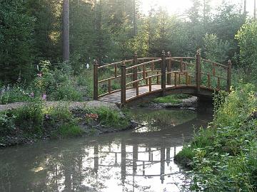 Arboretumin kaarisilta ilta-auringon kajossa.