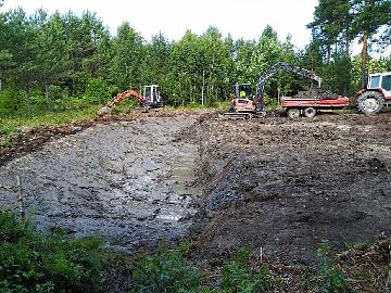 IMG_20200710_104230_1_lammen_toisen_puoliskon_kaivuu_valmis_1024px Half of the pond area was done first in order to get the geotextile and sand placed easier. 10-Jul-2020 Toinen puoli lammesta tehtiin ensin, jotta...