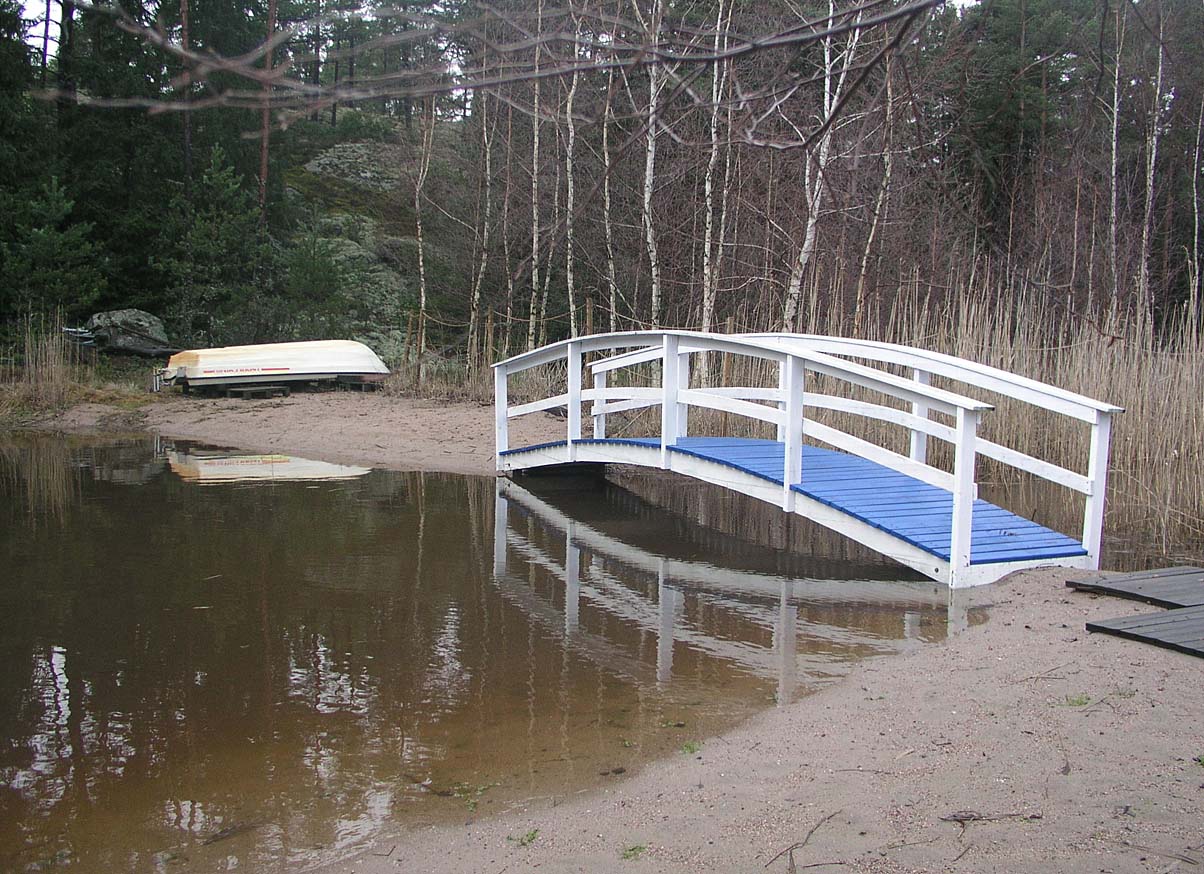 PC081623_silta_pieneen_saareen.jpg - Siltaa pitkin psee pienelle hiekkasaarelle.  Vene on jo nostettu maalle talven ajaksi. The bridge leads to a small sand island. The small boat is on shore during  winter time.